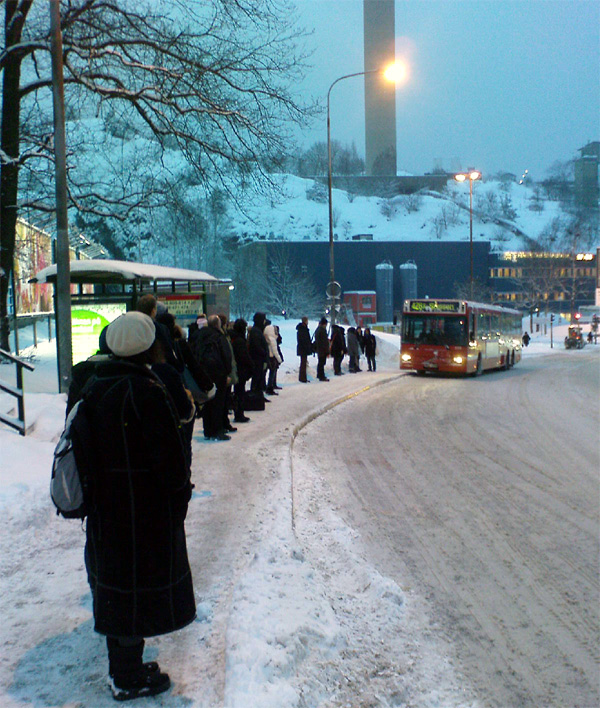Folk väntar på Nacka-Värmdö-bussarna i Henriksdal på vintern