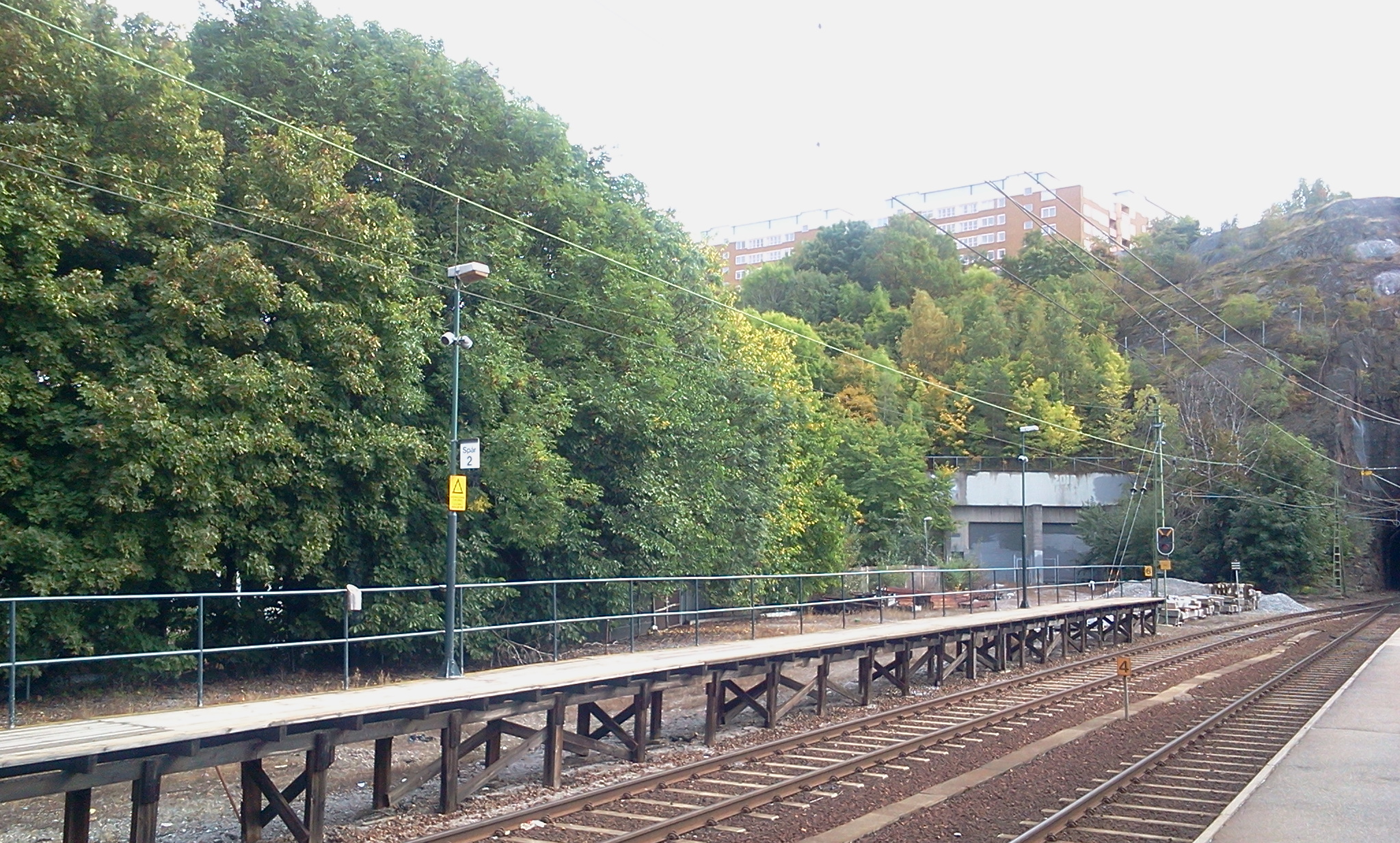 Perong för Saltsjöbanan, bangård och trädrad vid Henriksdal station