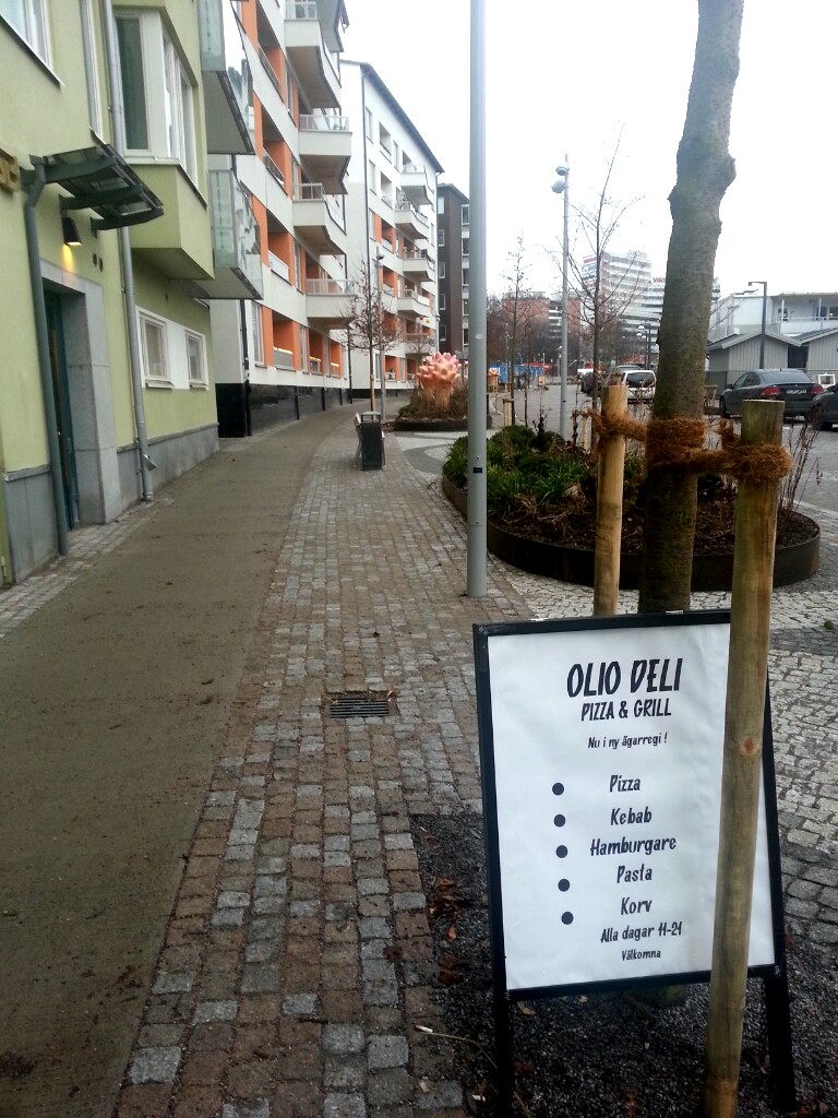 Henriksdalshamnen, Stockholm: OlioDeli med menyskylt på Henriksdalsallén