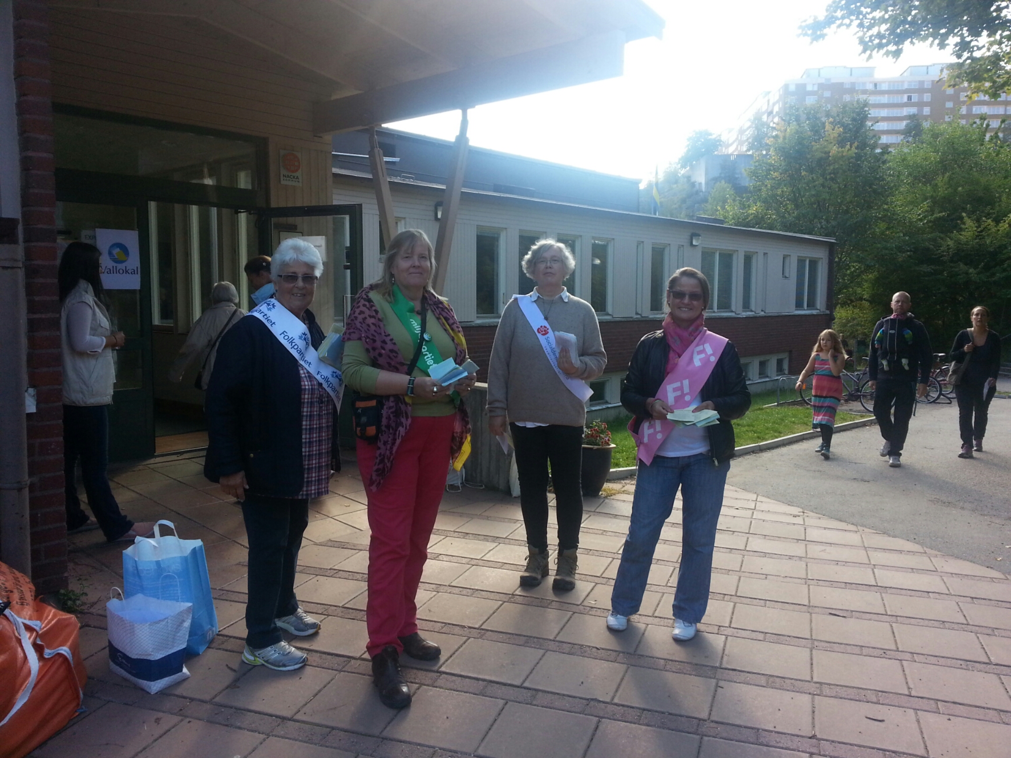 folkpartiets, miljöpartiets, socialdemokraternas och fi:s valarbetare delar ut röstsedlar utanför vilans skola i nacka